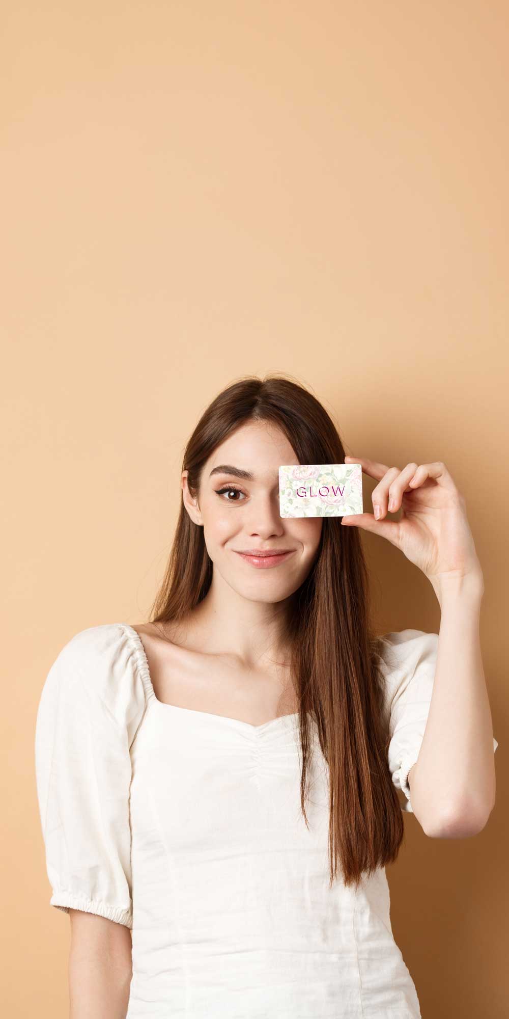 Judy, smiling, holding her Glow card up beside her face: the whole of her side of the comparison.
